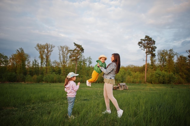 Mother with kids having fun together at meadow