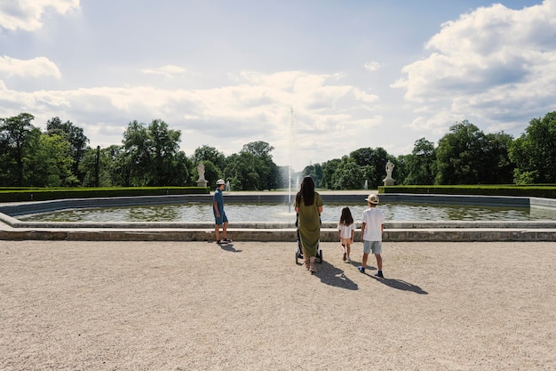 Mother with kids near fountain of Slavkov Castle also known as Austerlitz Castle is a Baroque palace in Slavkov u Brna Czech Republic