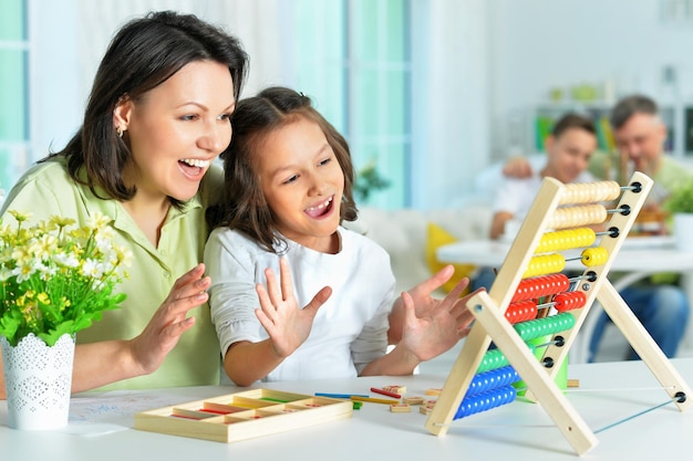 mother with little daughter counting with abacus