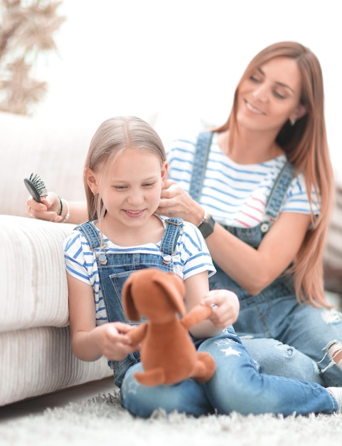 Mother with a little daughter sitting on the couch at home