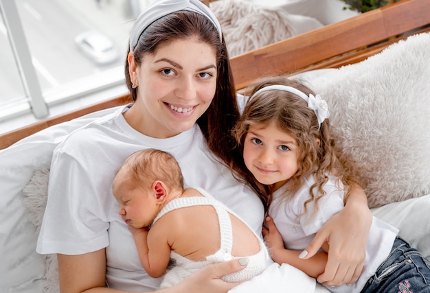 Mother with newborn baby and daughter