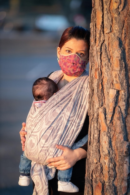 Photo mother with newborn in the new born sash in outdoor photo