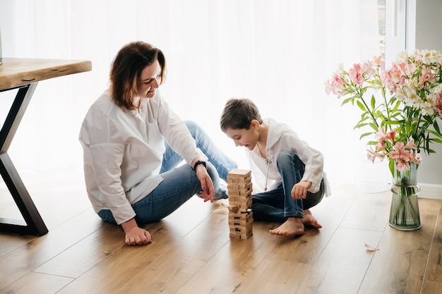 Mother with son playing game of physical skill tower