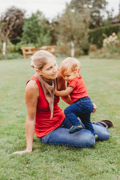 Mother with son sitting on field at park