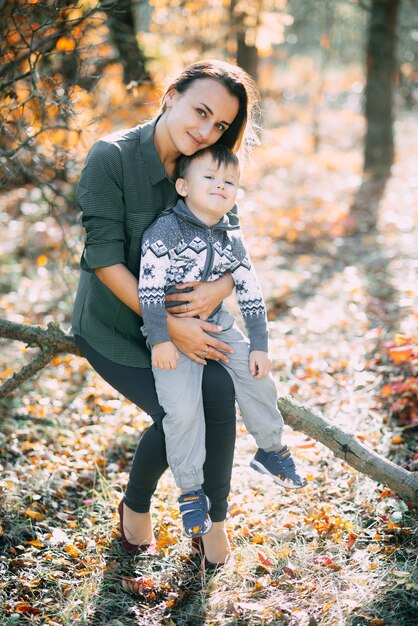 Photo mother with son three years in autumn the forest, embrace and tenderness