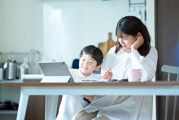 子供に邪魔されながら働く疲れた表情のお母さん