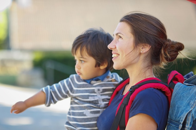 La madre con il bambino del bambino sta facendo un'escursione. il turista sta portando un bambino sulle sue yand nella città