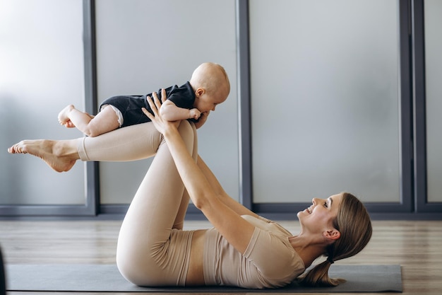 mother with toddler daughter exercising on mat