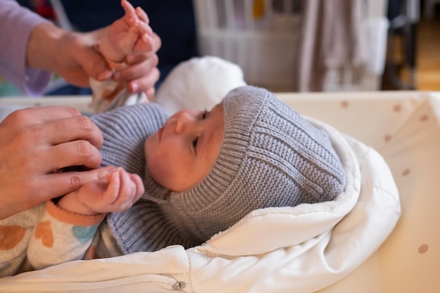 A mother woman puts on a warm jacket for a baby boy