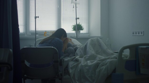 사진 어머니는 병원에서 치료를 받은 후 아픈 아이를 걱정합니다 심각한 아픈 아이가 침대에 누워 있습니다