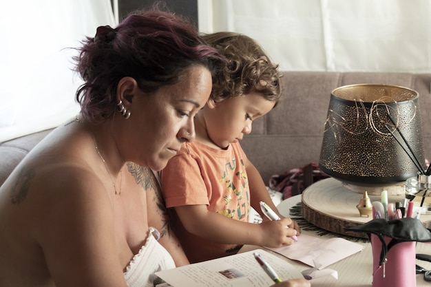 Mother and yearold caucasian son make crafts in caravan while on vacation