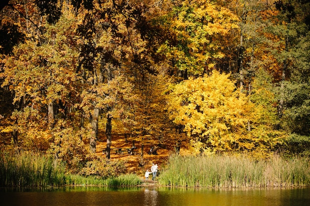 Motherhood concept. Mother and children standing in the forest next to a lake