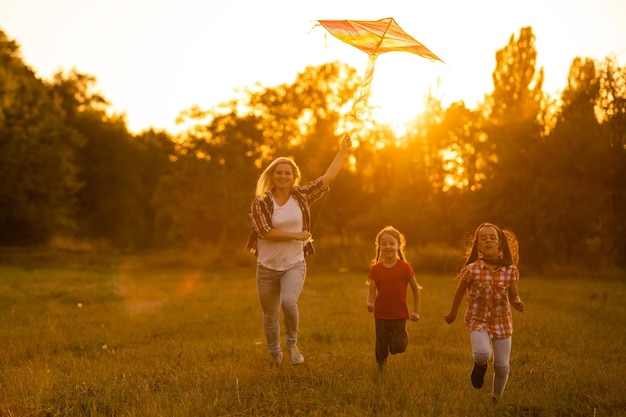 mothers and daughters in a field at sunset with an kite