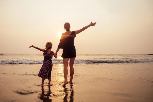 어머니의 날은 사랑, 부모, 행복한 가족이라는 개념입니다. 해변에서 일몰을 즐기는 엄마와 딸