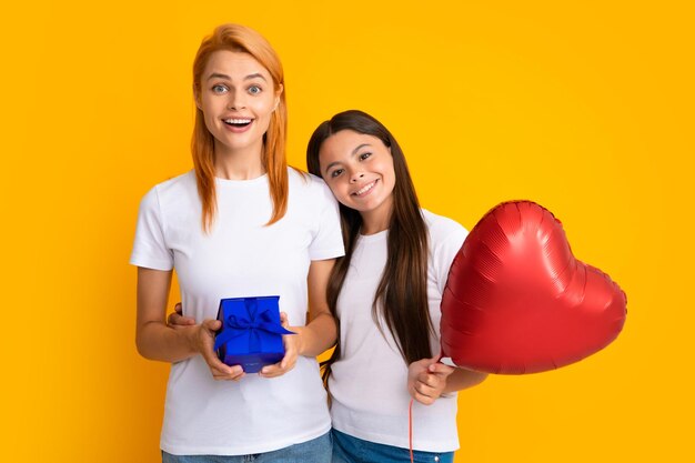 Mothers day Mother gives a gift to her teen daughter isolated background Happy family concept Girl