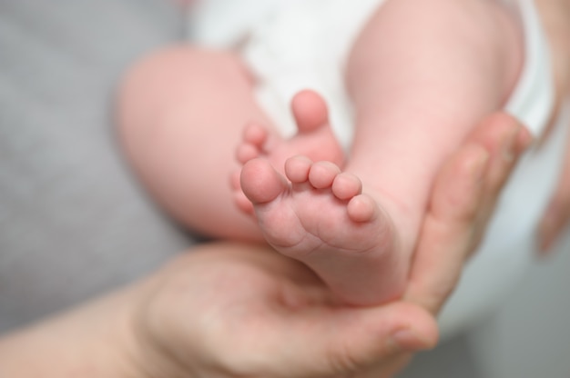 Mothers hands holding newborn baby feet