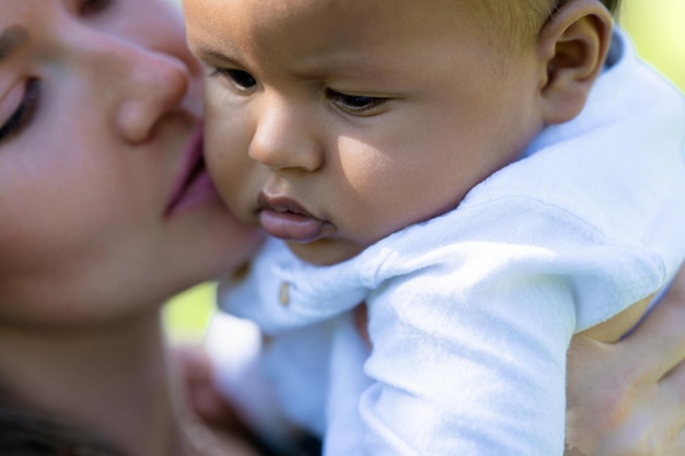 母親が親密にキスする 母が多民族の赤ちゃんをキスする 母が多民族の子供をキスする 肖像画