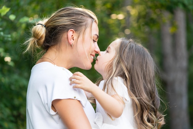 Mothers love Embrace and kiss family concept Mom and daughter hugging and kissing Happy family and lovely mom and daughter spend time together mothers day Family and motherhood concept