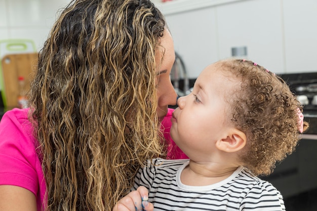 Madri che giocano con la figlia. accarezzare il naso.