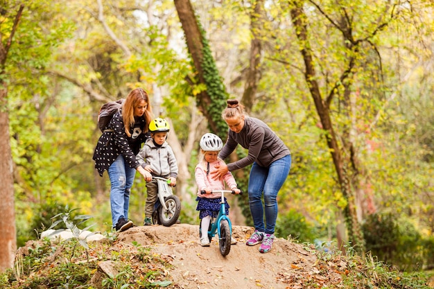 自転車に乗って子供たちを教え、サポートする母親