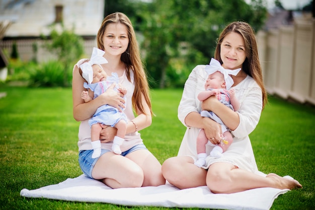 Mothers with little daughters in their arms