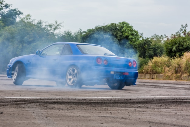 Motion blur car drifting, Professional driver drifting car on race track with smoking.