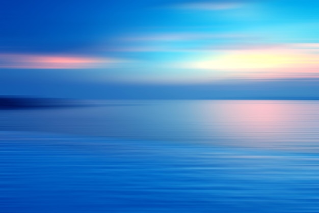 Motion blurred background of refraction in water. Panoramic dramatic view of Infinity sunset on the sea at twilight times.