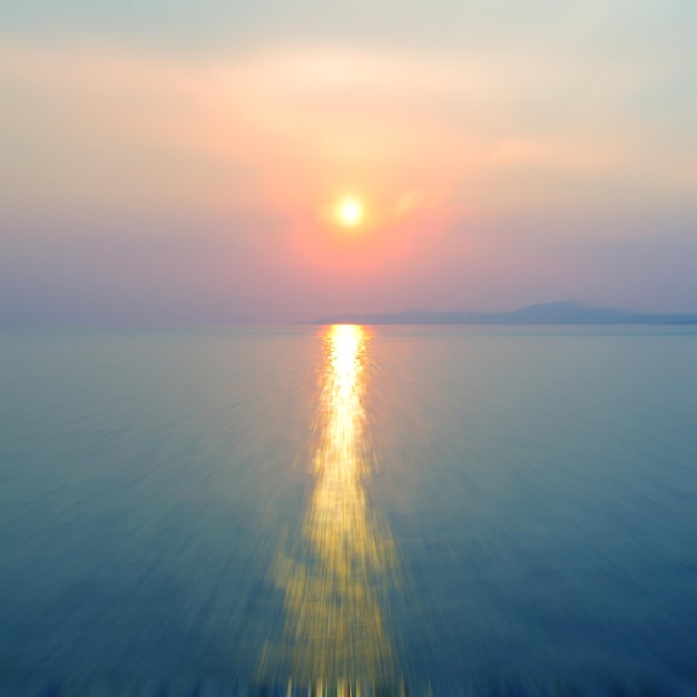 Movimento sfocato sullo sfondo della rifrazione nell'acqua vista panoramica dell'infinito tramonto sul mare