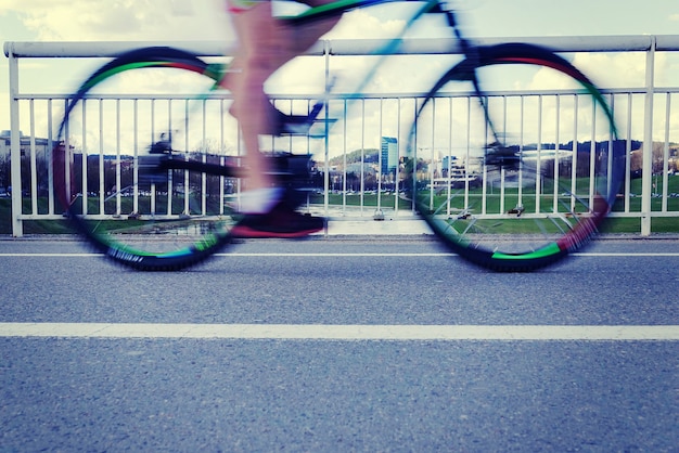 Photo motion blurred cyclist rides over the bridge