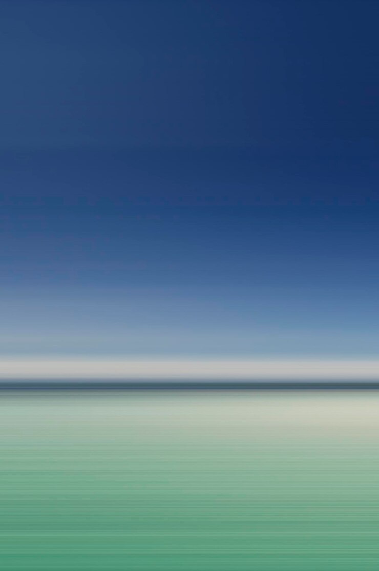 Motion blurred photograph of a tropical beach and sea under a blue sky in summertime
