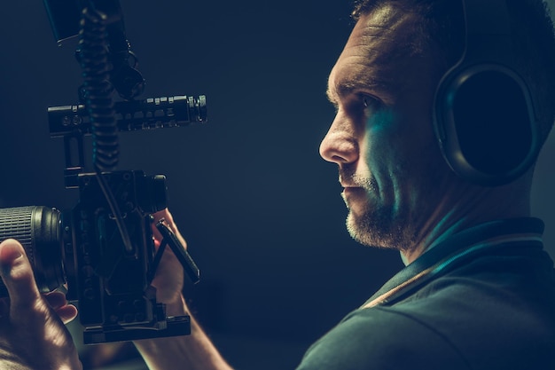 Photo motion picture theme videographer camera operator with professional digital recording device in his hands