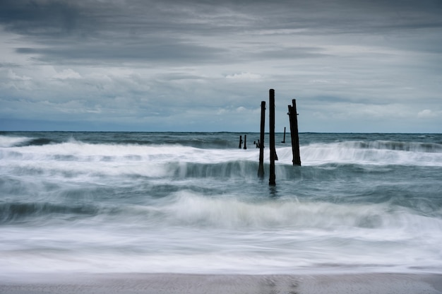 Motion of Wave hitting decay wooden bridge on the beach in stormy weather