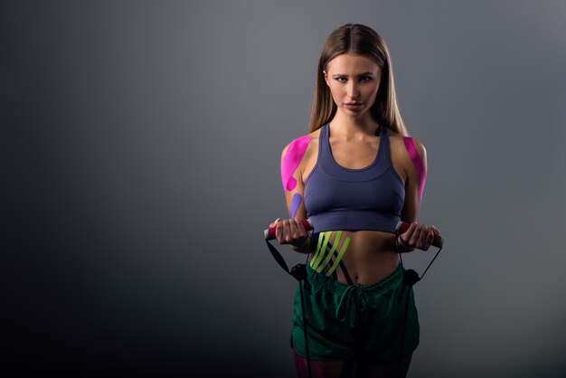 Motivated woman performs exercises with rubber