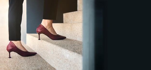 Motivation and challenging concepts. woman power. steps forward
into a success. low section of business woman walking up on
staircase