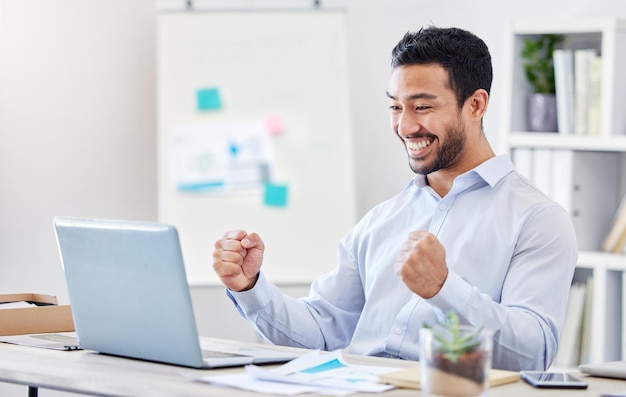 Motivazione, successo e sì con un uomo d'affari in festa e che lavora su un laptop vicino alla sua scrivania in ufficio invia una buona notizia e sorridi con un giovane e felice impiegato maschio che fa il tifo al lavoro