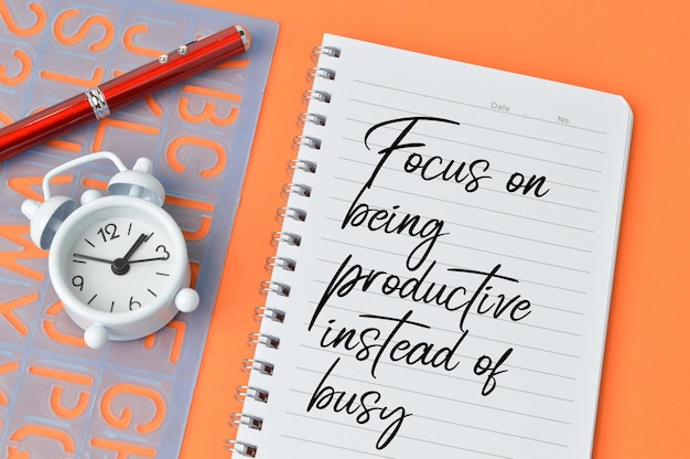 Motivational quote written with FOCUS ON BEING PRODUCTIVE INSTEAD OF BUSY Top view