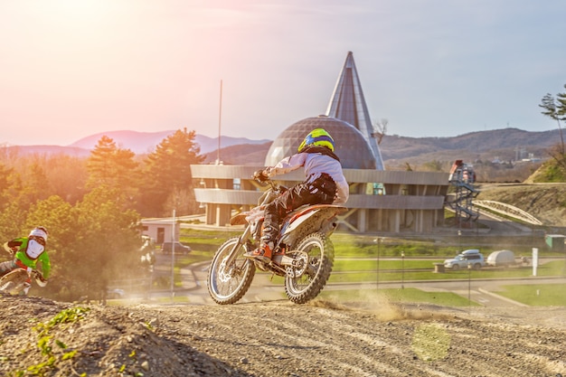 Moto cross biker at race- a sharp turn and the spray of dirt, rear view - close up