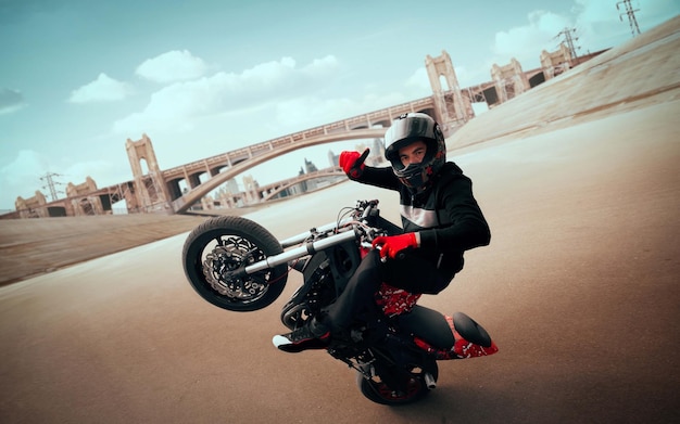 moto rider making a stunt on his motorbike biker doing a difficult and dangerous stunt