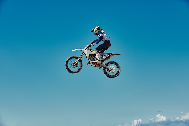 Motocross concept, a biker goes off-road making extreme skiing. In pursuit of adrinalin, sport concept. Dangerous sport.