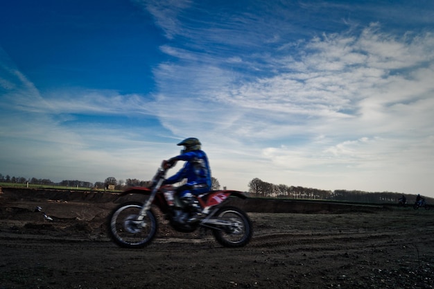 Photo motocross racer on dirt road against sky