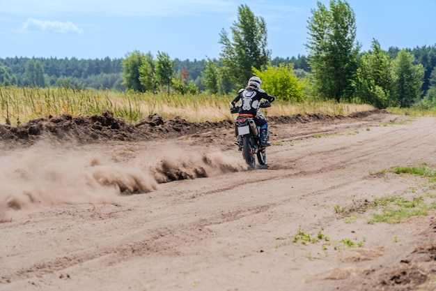 Photo motocross rider riding on extreme dust track