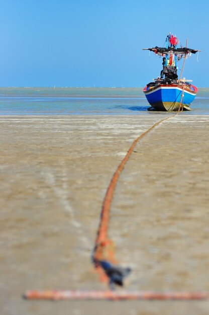 Motor boat on beach against clear sky