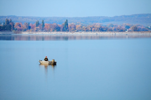 写真 漁師とモーターボートが湖の水を航行しています