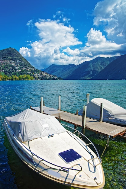 Photo motor boats at the promenade of the luxurious resort in lugano on lake lugano and alps mountains, ticino canton, switzerland.