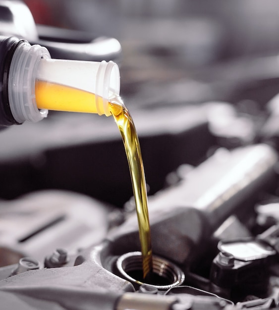 Motor oil pouring to car engine.