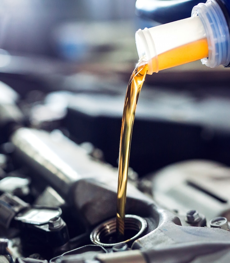 Photo motor oil pouring to car engine.