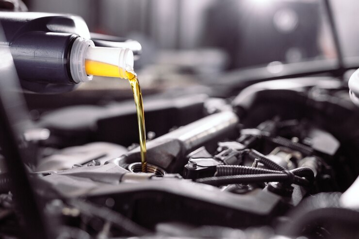 Photo motor oil pouring to car engine.