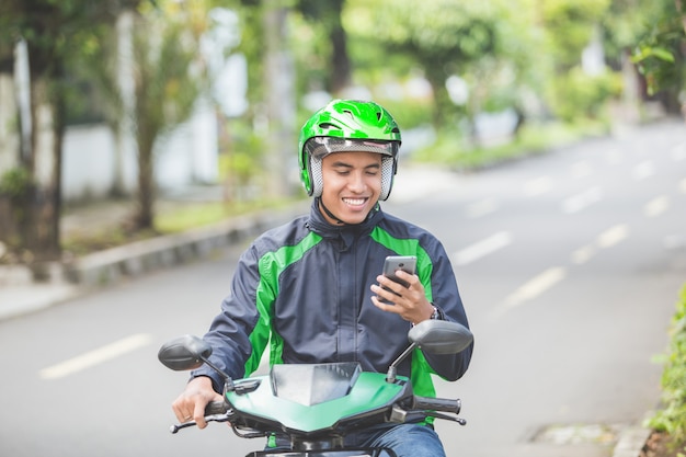 Foto motor taxichauffeur die bestelling opneemt via de mobiele telefoon online app