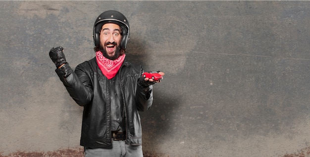 Foto cavaliere della motocicletta che tiene un modello di auto rossa