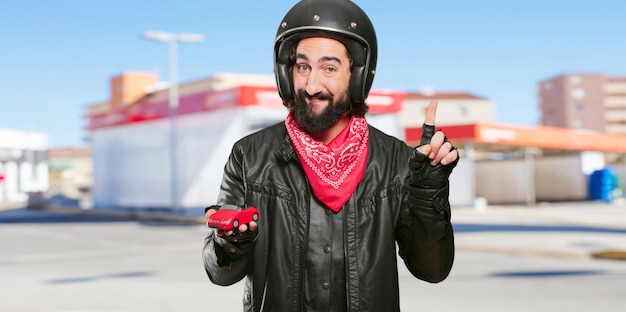 Motorbike rider holding a red car model